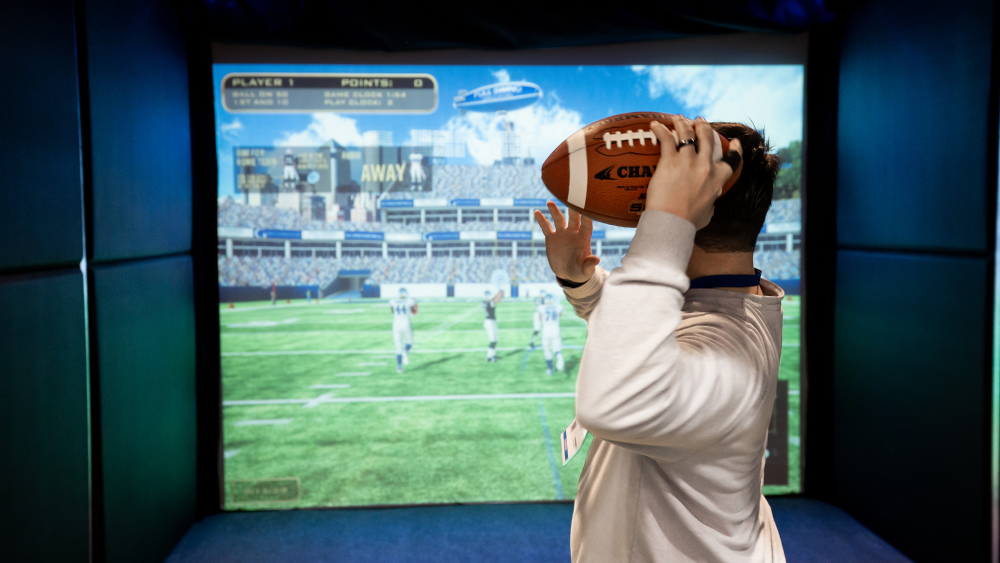 Man playing football game at Topgolf Swing Suite